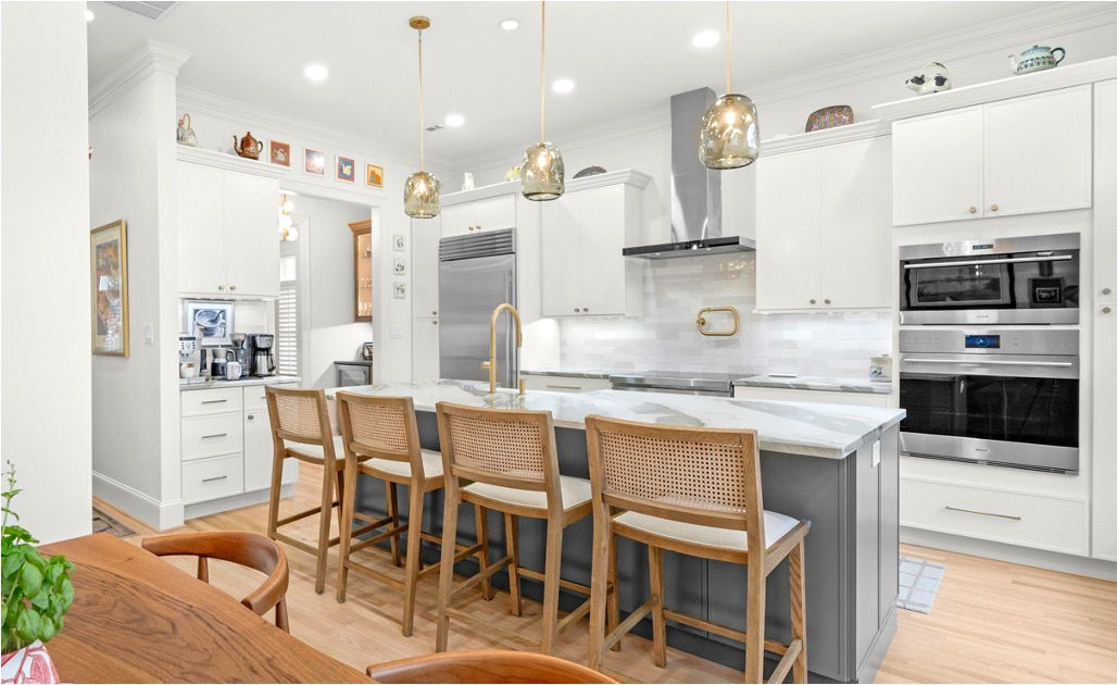 Refined kitchen with a marble island, seating and integrated appliances